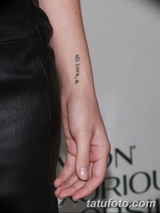 Фото татуировки на руке: тонкая надпись 'all love, A' черным цветом. Простой и элегантный дизайн.