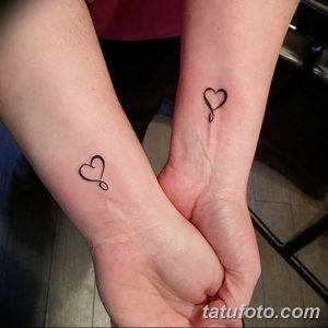 Фото парных татуировок на запястьях с изображением простых черных сердец. Нежный и минималистичный рисунок татуировки.