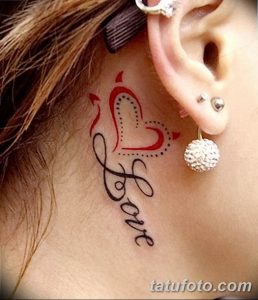Черно-красное фото татуировки с надписью 'Love', стилизованной под сердце и украшенной точками, на шее. Нежный и привлекательный дизайн.