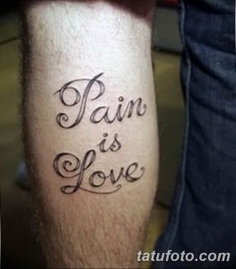 Фото тату на предплечье: каллиграфическая надпись 'Pain is Love' черными чернилами, выполненная в элегантном стиле.