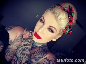 Фотография девушки с ярким макияжем и обилием татуировок на шее и плечах. На голове красный бандаж.