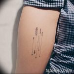Фото тату на бедро с изображением стрел и перьев в минималистичном стиле. Тонкие линии и графичный рисунок татуировки.