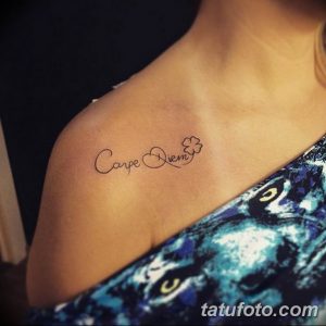 Фото тату надписи "Carpe Diem" с изображением четырехлистного клевера на плече. Элегантный шрифт, минималистичный дизайн, мотивационная татуировка.