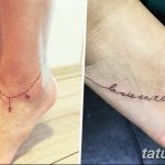 Фото тату на лодыжке: черная цепочка с подвесками и надпись 'la vie en rose' с цветком.