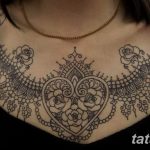 Фото тату сложного узора в стиле мехенди на груди и плечах. Детализированный рисунок татуировки, напоминающий кружево.