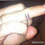 Фото тату с двумя вертикальными линиями на пальце и небольшим контуром сердца на ладони. Простой и символичный рисунок.