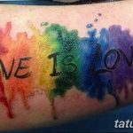 Фото тату с надписью 'Love is Love', выполненной в виде радужных брызг краски на руке. Яркий и красочный символ любви и равенства.
