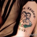 Фото тату: Парная татуировка на плече: портреты двух мужчин в олдскульном стиле, окруженные цветами и датой. Яркий и запоминающийся рисунок.