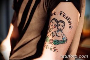 Фото тату: Парная татуировка на плече: портреты двух мужчин в олдскульном стиле, окруженные цветами и датой. Яркий и запоминающийся рисунок.