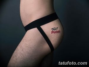 Фото татуировки с надписью "SLUT PRANNA" на бедре человека. Смелый и провокационный рисунок татуировки.