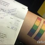 Фото тату: изображение чека с надписью 'Can't help someone who doesn't love Jesus. Bad tattoo' и две радужные полосы на руке.