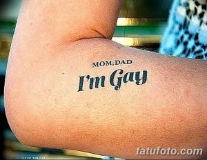 Фото татуировки на руке: надпись "Mom, Dad I'm Gay" черными чернилами. Простой шрифт, прямое сообщение.