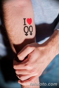 Фото татуировки на руке: надпись "I Love" с сердечком и символами мужского и женского пола. Простой дизайн, четкие линии.