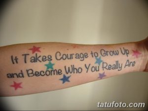 Фото тату на предплечье: надпись 'It Takes Courage to Grow Up and Become Who You Really Are' с небольшими звездами. Мотивирующий и символичный рисунок татуировки.