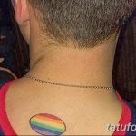 Фото тату: круглая радужная татуировка на спине мужчины, расположенная у основания шеи.