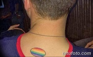 Фото тату: круглая радужная татуировка на спине мужчины, расположенная у основания шеи.