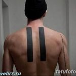 Фото тату: минималистичная татуировка двух вертикальных черных полос на спине мужчины. Стильный и лаконичный дизайн для ценителей простоты.