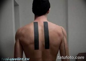 Фото тату: минималистичная татуировка двух вертикальных черных полос на спине мужчины. Стильный и лаконичный дизайн для ценителей простоты.