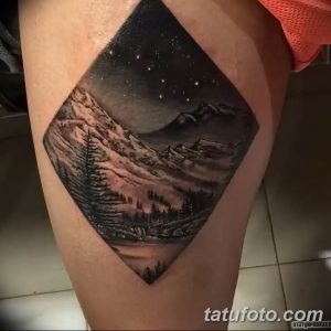 Фото тату на ноге, выполненное в стиле blackwork с изображением горного пейзажа, звездного неба и еловых деревьев.