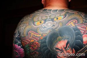 Фото тату на спине: детализированный рисунок японского дракона и самурая в ярких цветах, выполненный в традиционном стиле.