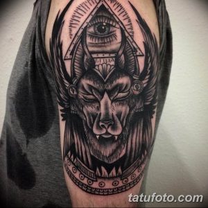 Фото тату льва с глазом Гора на предплечье, выполненное в стиле blackwork с использованием геометрических элементов и детализированной штриховки.