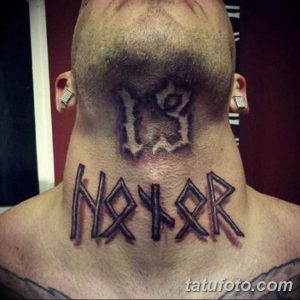 Фото татуировки на шее мужчины с надписью "HATER" выполненной в готическом стиле черными чернилами.