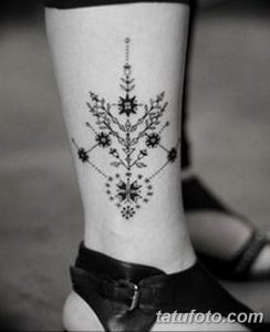 Фото татуировки на лодыжке женщины, выполненной в стиле blackwork с использованием геометрических узоров и тонких линий.