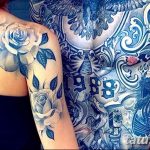 Фото тату на плече и спине с изображением роз, голубей и цифр 1988. Детализированный рисунок в черно-белой гамме.