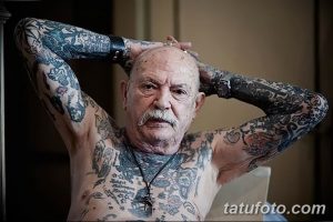 Фото пожилого мужчины с полностью покрытым татуировками телом, демонстрирующее искусство татуировки на протяжении всей жизни.