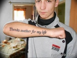 Фото тату: надпись "Thenks mother for my life" на руке молодого человека. Минималистичная и трогательная татуировка.
