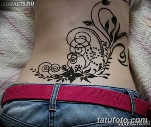 Фото тату мехенди на животе: красивый узор с цветами и завитками, выполненный в коричневых тонах. Идеально для тех, кто ищет идеи для временной татуировки.