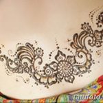 Фото тату мехенди на женском животе, выполненное в коричневых тонах. Рисунок состоит из растительных узоров и геометрических фигур.