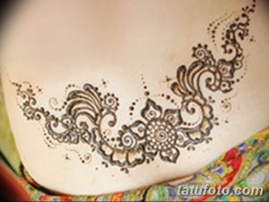 Фото тату мехенди на женском животе, выполненное в коричневых тонах. Рисунок состоит из растительных узоров и геометрических фигур.