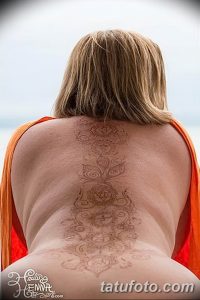 Фото тату хной на спине: сложный коричневый узор с цветочными и геометрическими элементами, расположенный между лопатками.