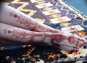 Фото тату хной на обеих ногах, демонстрирующее парные узоры с растительными и геометрическими элементами. Детализированный рисунок в коричневых тонах.