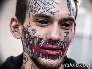 Фото татуировки на лице: мужчина с татуировкой, имитирующей острые зубы и устрашающий вид. Татуировка на губах и подбородке.