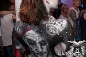 Фото тату на спине: реалистичное изображение лица, черепа и абстрактных элементов в черно-белой гамме. Детализированный рисунок татуировки.