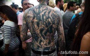 Фото тату на спине мужчины. Изображены мифологические сюжеты с множеством фигур и деталей, выполненные в черно-белой гамме.