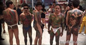Фото: группа мужчин с масштабными японскими татуировками Ирэдзуми, покрывающими спины и тела. Традиционные сюжеты, яркие цвета.