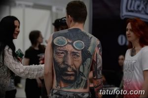 Фото тату: масштабная татуировка на спине мужчины, изображающая портрет старика в очках и детализированные элементы.