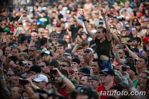 Фото тату: Большая толпа людей на тату-фестивале, выражающих восторг и радость, демонстрируя атмосферу праздника.