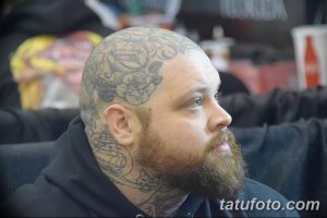 Фото тату: Мужчина с бородой и татуировкой розы на голове, демонстрирующий классический стиль татуировки.