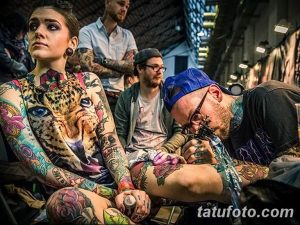 Фото тату: девушка с яркой и детализированной татуировкой леопарда, покрывающей ее грудь, плечи и руки.