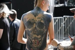Фото тату: впечатляющая татуировка черепа, покрывающая всю спину мужчины. Детализированный рисунок с реалистичными тенями и текстурами.