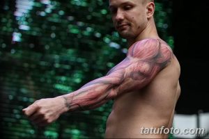 Фото тату: реалистичная татуировка, изображающая анатомию мышц на руке мужчины. Татуировка выполнена в красных и розовых тонах.