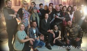 Фотография большой группы мастеров тату на фестивале, демонстрирующих свою профессиональную команду и творческую атмосферу.