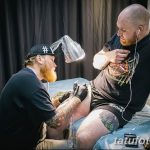 Фото тату на боку мужчины. Детализированный рисунок с использованием темных тонов и четких линий. Мастер тату работает над татуировкой.