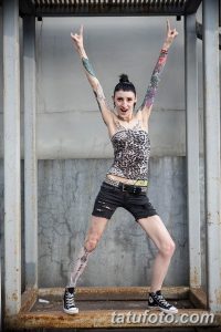 Фотография демонстрирует девушку с татуировками на руках и ногах, позирующую в дерзком и уверенном образе.
