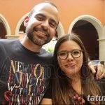 Фотография пары с татуировками на руках. Мужчина в серой футболке, женщина в синем платье.