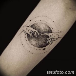 Фото тату: татуировка в стиле dotwork, изображающая руки, тянущиеся друг к другу на фоне круга из точек. Черно-белый рисунок на предплечье.